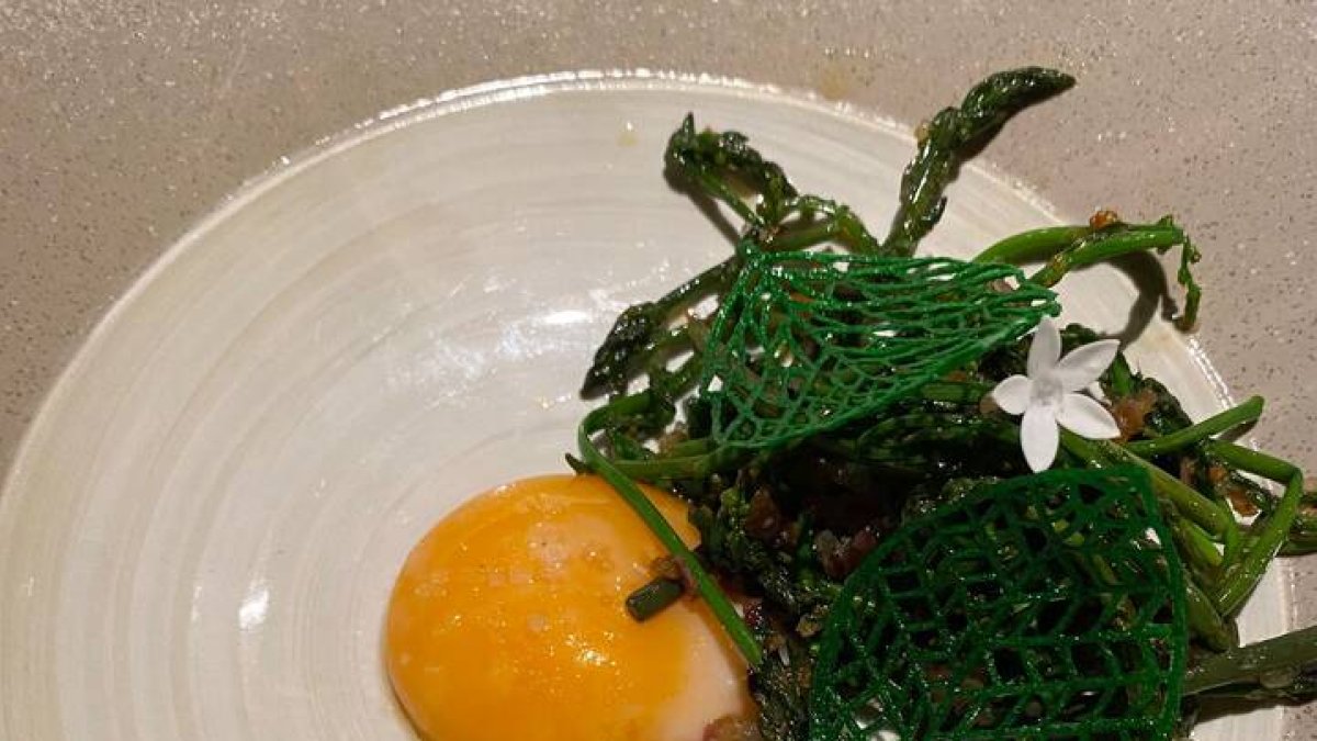 Esparraguines, bien salteados, con yema de corral sobre panceta ibérica.
