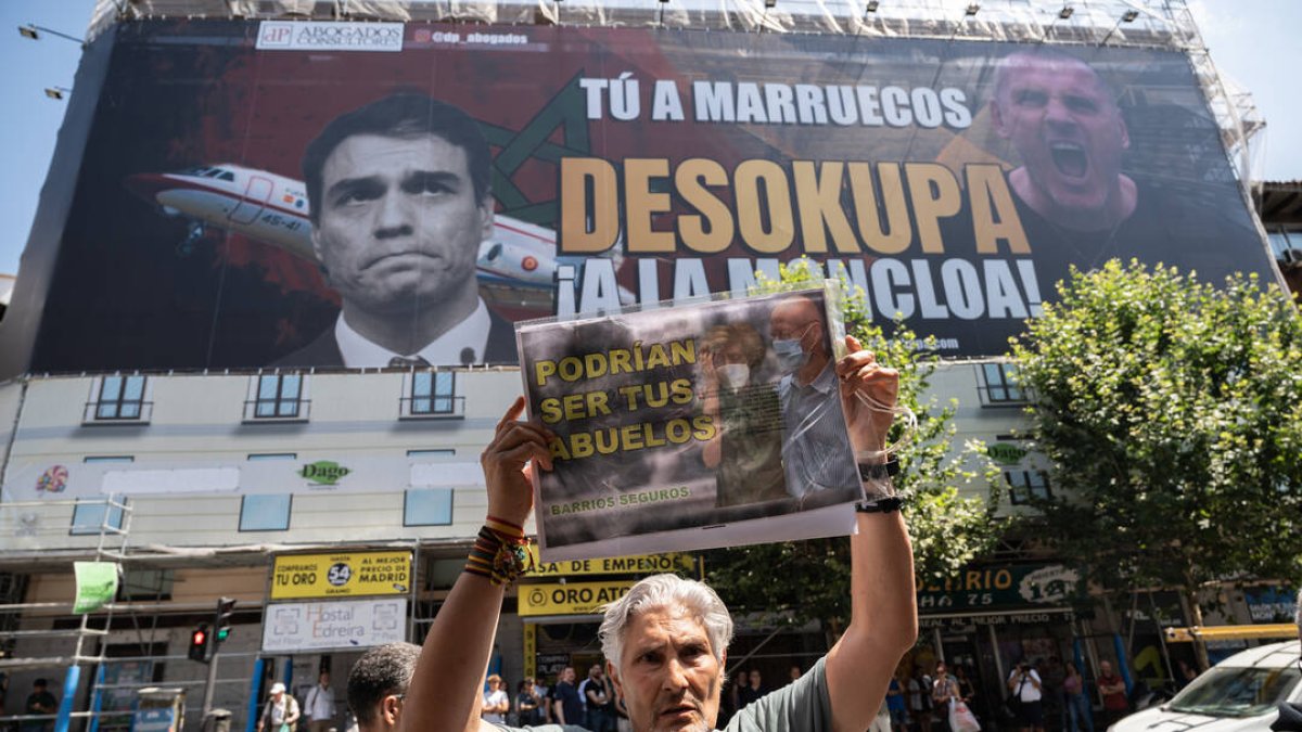Un hombre sujeta una pancarta el día en el que la plataforma Desokupa ha desplegado una lona en Atocha contra el presidente del Gobierno, a 3 de julio de 2023, en Madrid