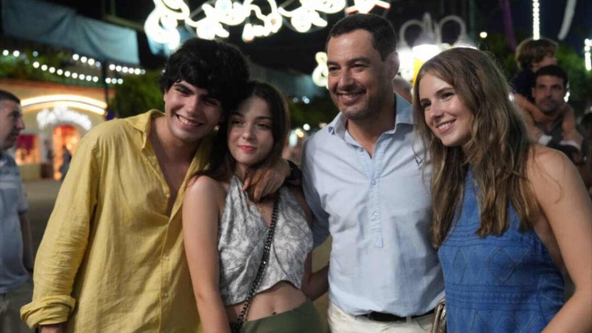 El presidente de la Junta de Andalucía, Juanma Moreno, con unos jóvenes.