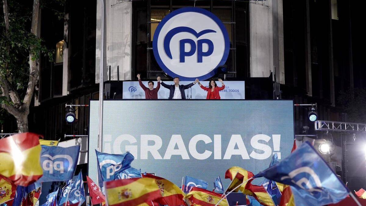 Almeida, Feijóo y Ayuso celebrando la victoria del PP en el balcón de Génova.