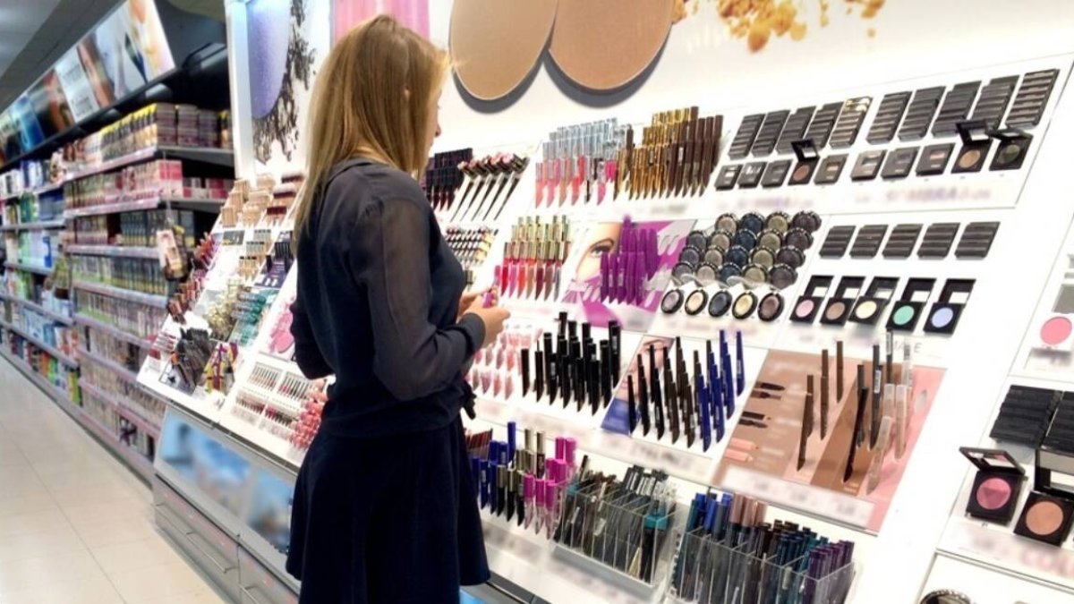 Mujer mira expositor de productos cosméticos