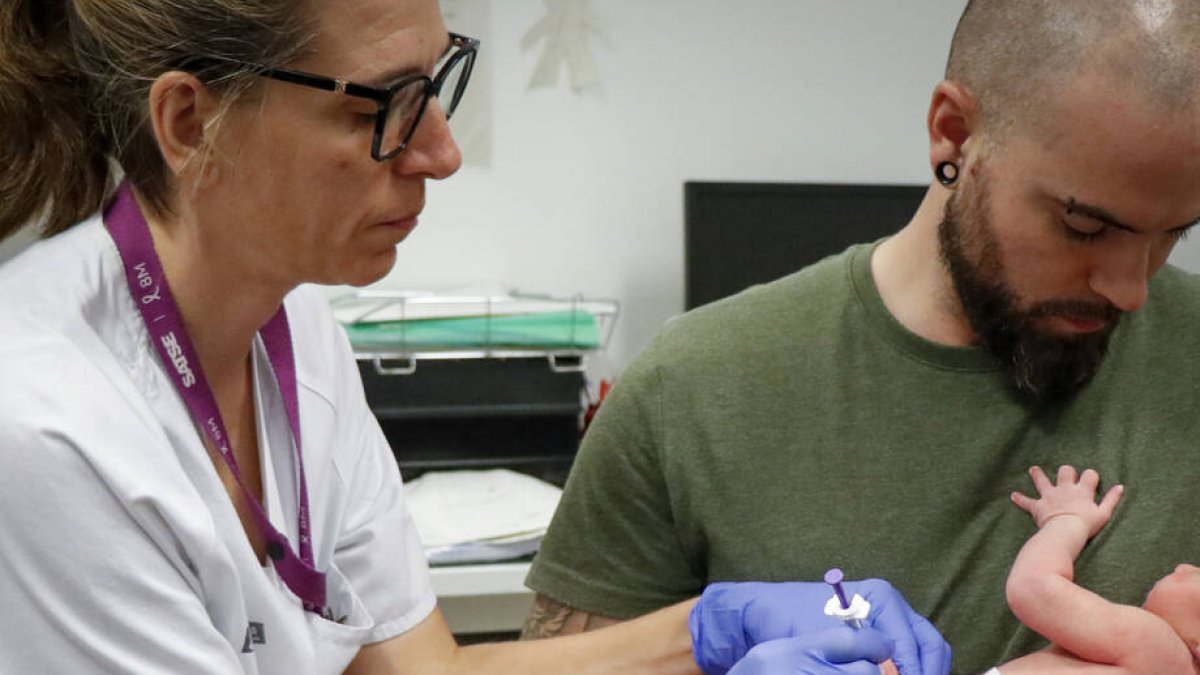 Personal sanitari vacunant a un bebé