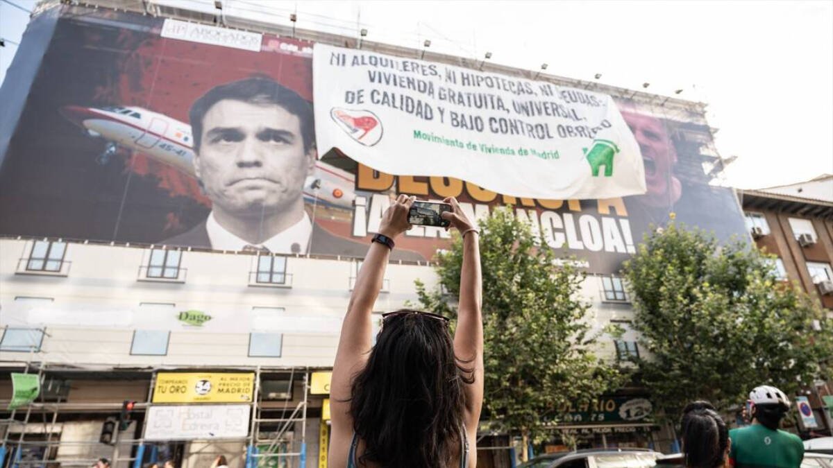 Lona desplegada por el Movimiento de Vivienda de Madrid encima del cartel de Desokupa, donde se lee ‘Ni alquileres, ni hipotecas, ni deudas.