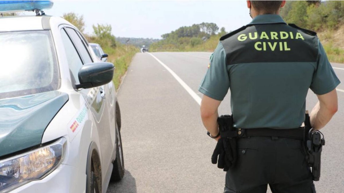 Imagen de archivo de un agente de la Guardia Civil junto a su coche patrulla