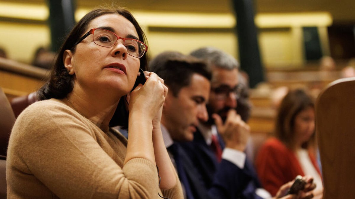 Una diputada se pone el pinganillo en un debate en el Congreso.
