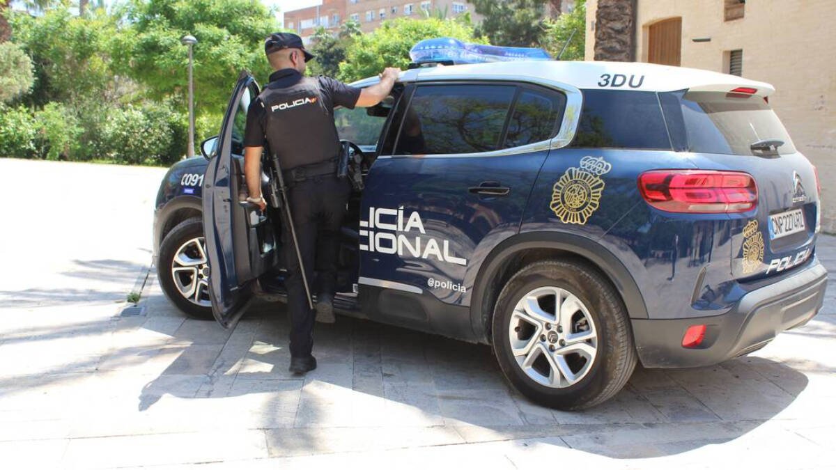 Agente junto a vehículo policial