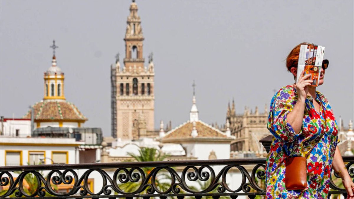 Una mujer trata de protegerse del sol abrasador en Sevilla.