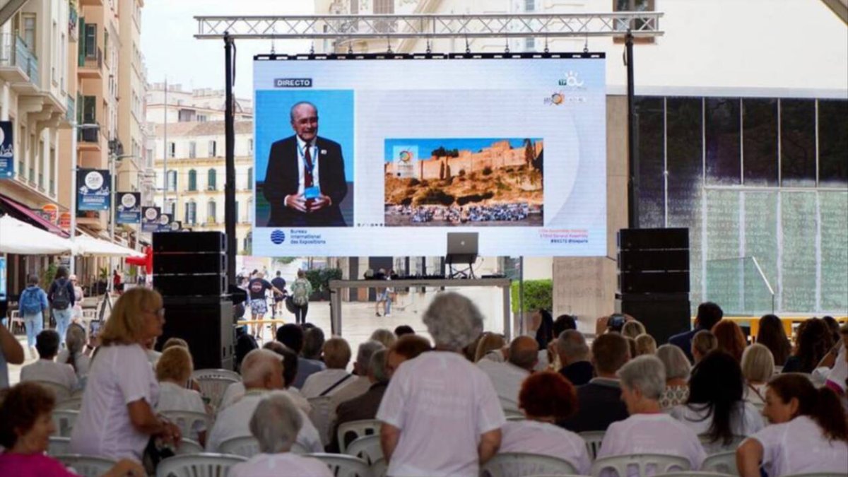 Vecinos de Málaga siguiendo la elección en París de la sede de la Expo 27.