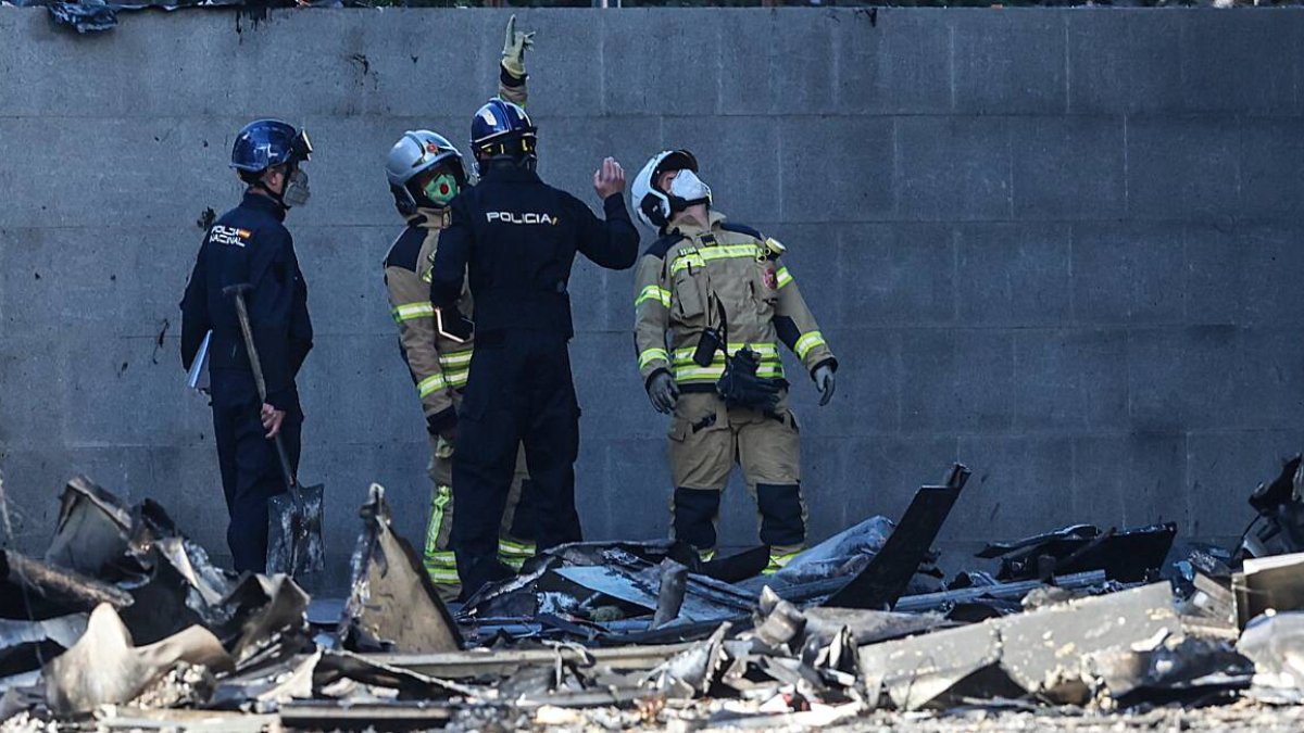 Varios agentes de la Policía Nacional junto al edificio incendiado del barrio de Campanar