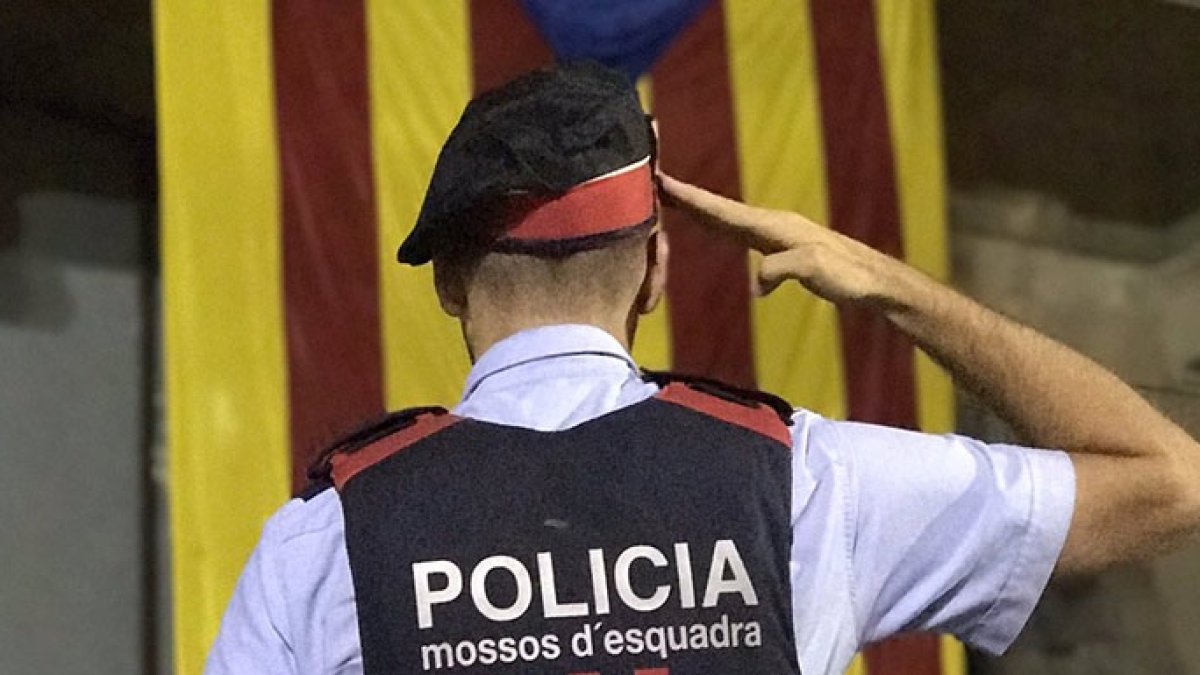 Albert Donaire, líder de los mossos rebeldes, rinde honores a una estelada, símbolo de los independentistas.