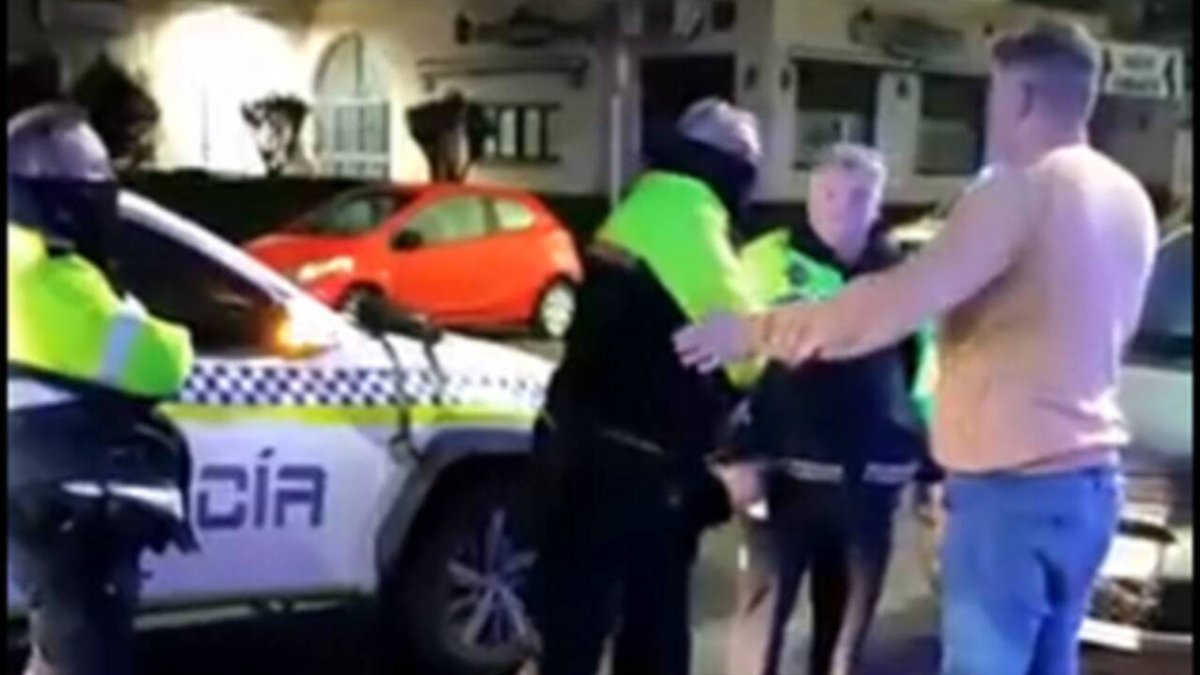 Momento en el que el agente saca la porra y golpea al joven.