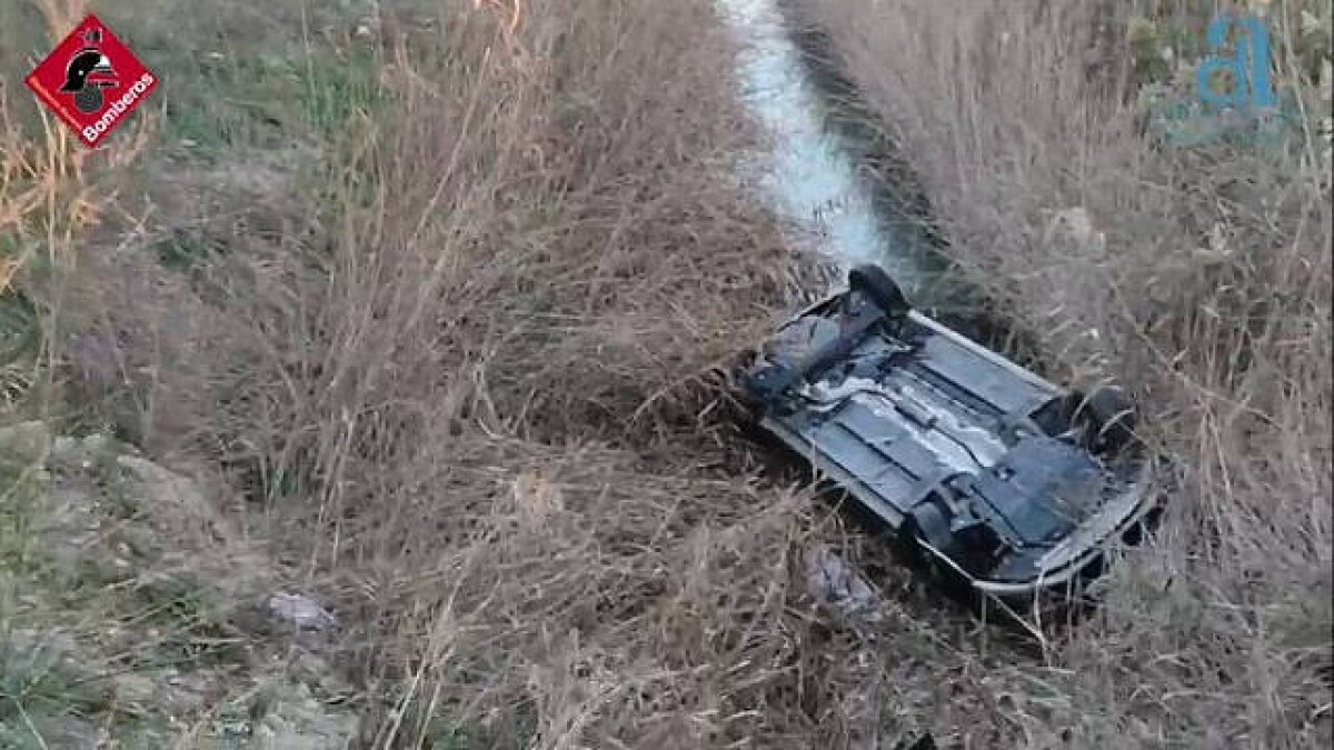 El vehículo ha quedado volcado boca abajo sumergido parcialmente en el agua de la acequia