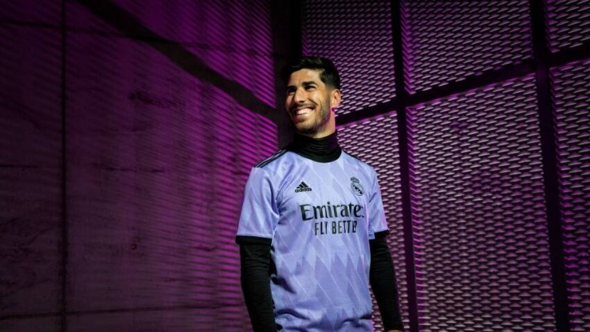 Asensio posa con una de las nuevas camisetas del Real Madrid.