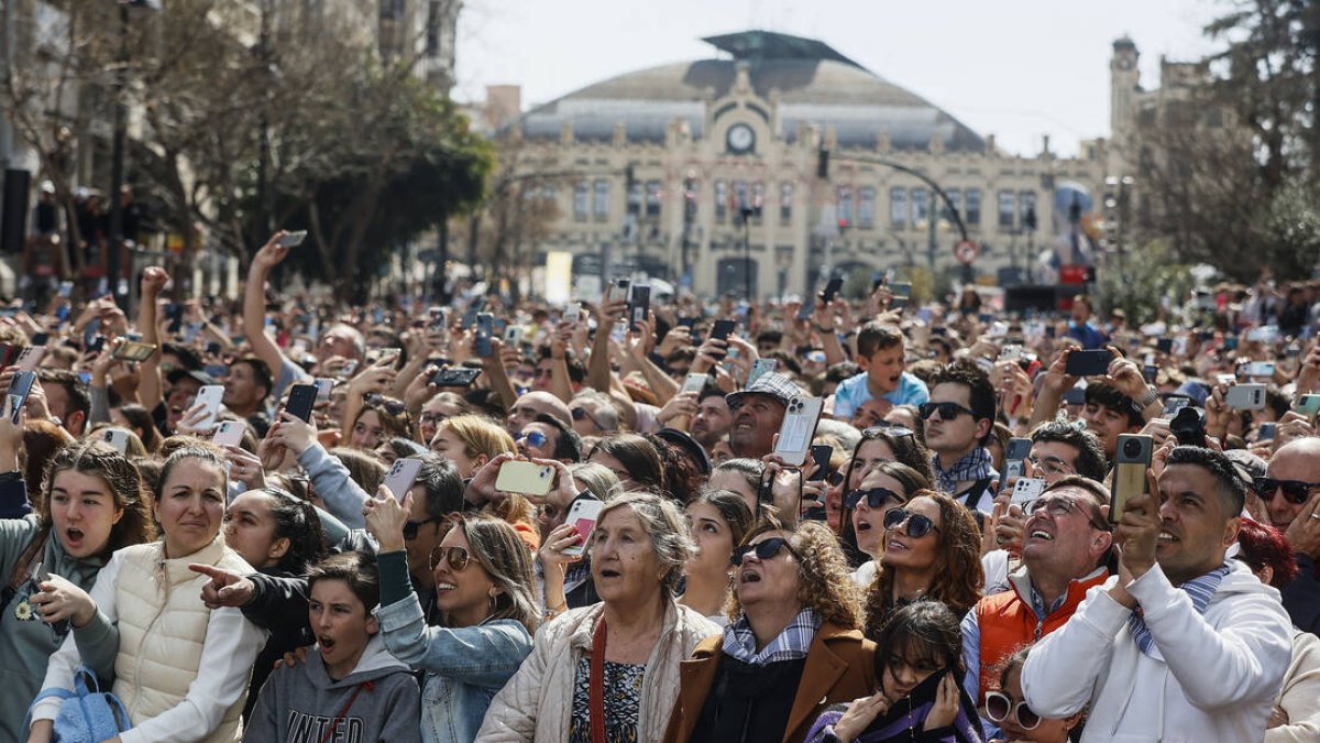 Decenas de personas durante la mascletà de la plaza del Ayuntamiento de Valencia.