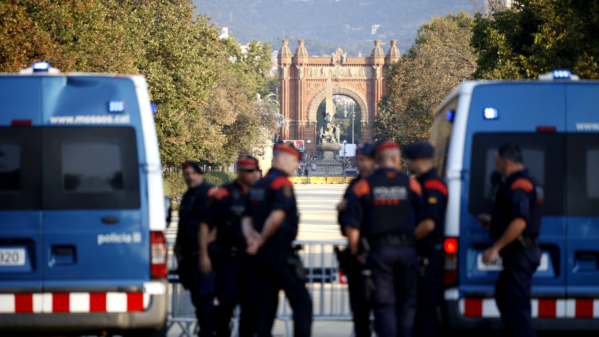 Agentes de los Mossos d' Esquadra y varias personas en las inmediaciones del Parlament de Cataluña.