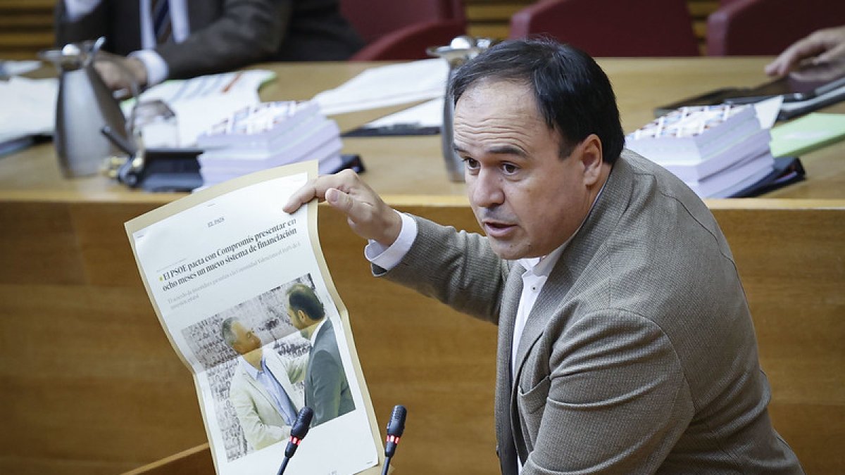 Juanfran Pérez Llorca, síndica del PP, durante el debate de política autonómica enseña un recorte de prensa en el que se puede ver a Baldoví hablando con el ex ministro socialista José Luis Ábalos..