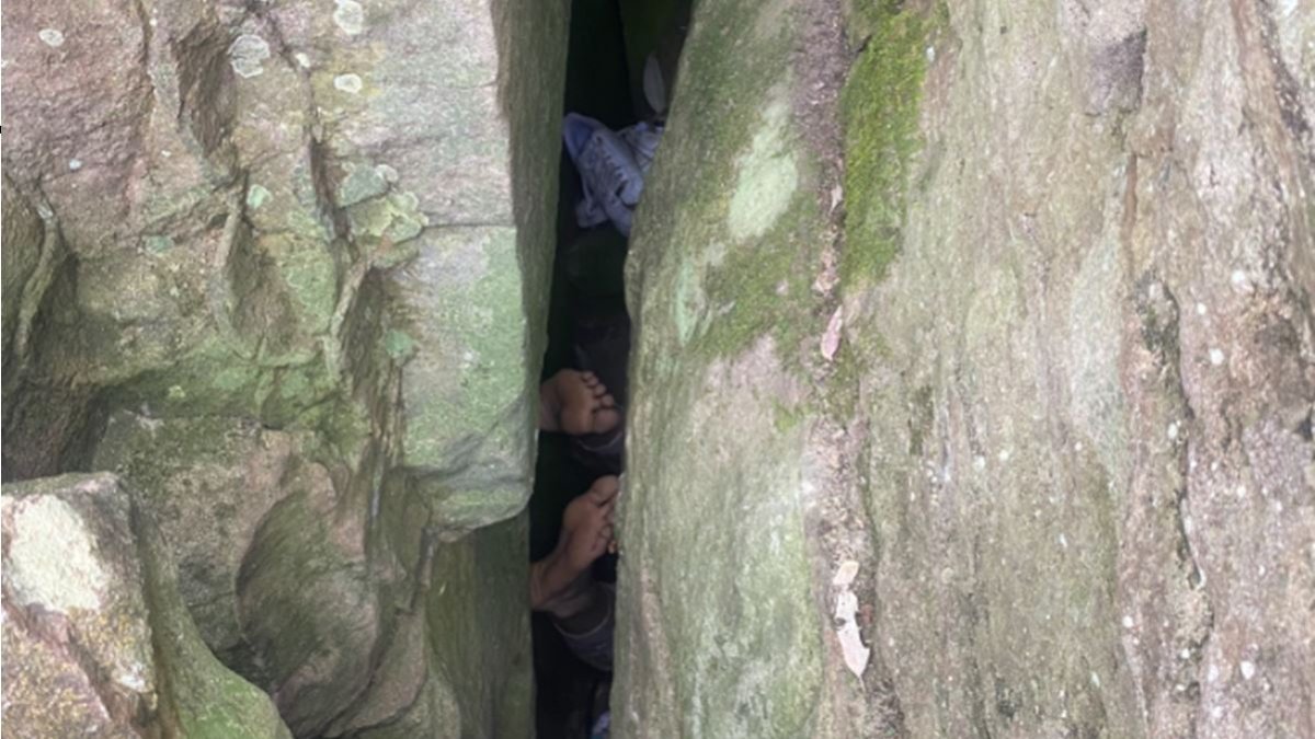Mujer atrapada entre rocas tratando de recuperar su móvil