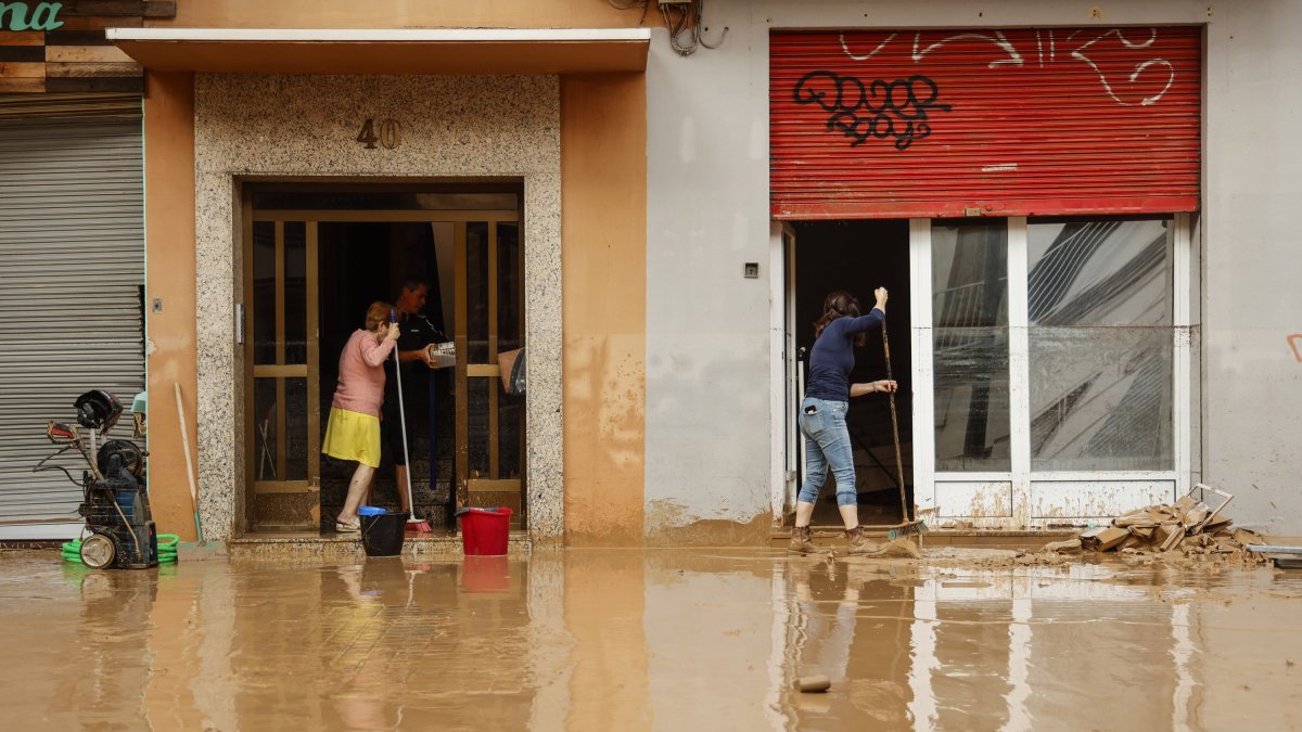 Varias personas limpian la zona afectada por el temporal