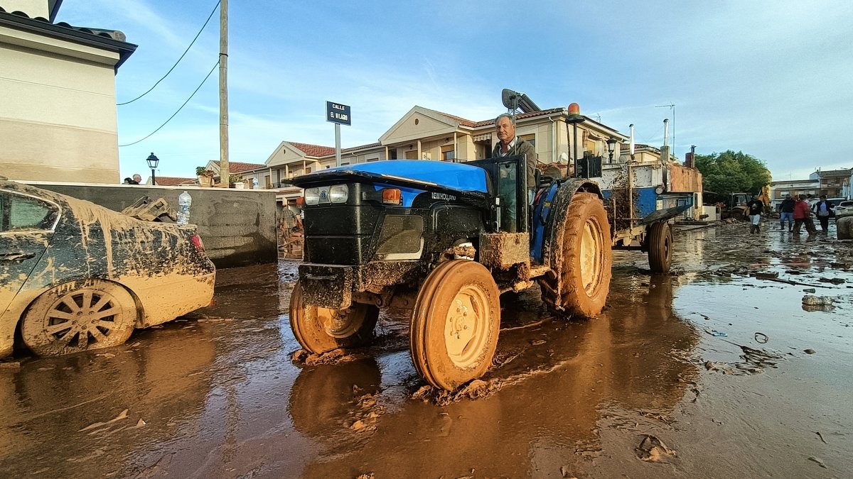 Un señor con su tractor colabora en la limpieza de las calles, a 1 de noviembre de 2024, en Utiel.