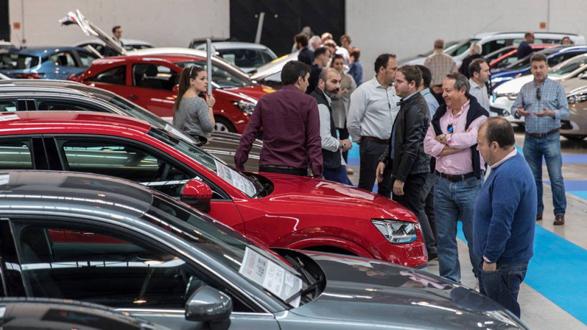 Compradores mirando coches de segunda mano