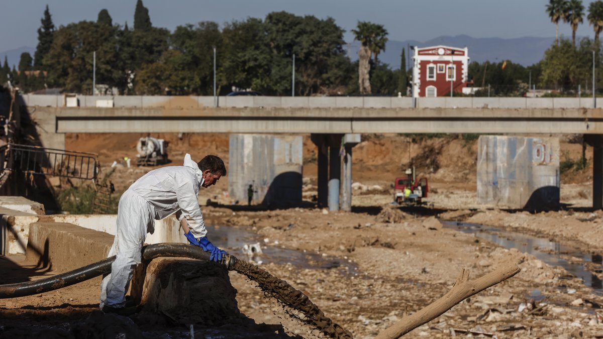 Un hombre tira barro recogido durante las labores de limpieza