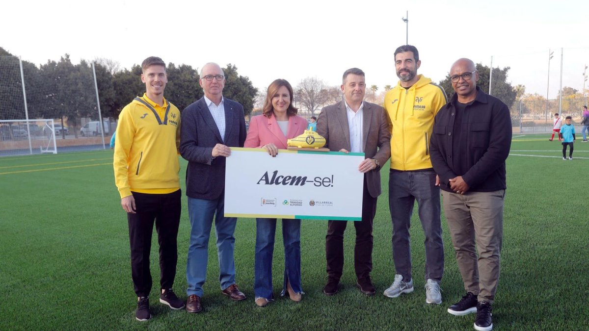 María José Catalá y jugadores del Villarreal CF en el campo de fútbol de La Torre reconstruido gracias a ayudas de Juan Roig