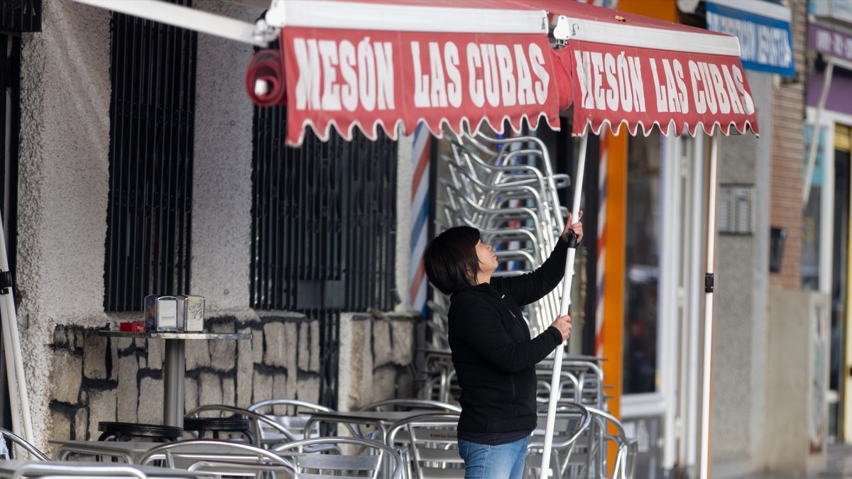(Foto de ARCHIVO)
Una camarera levanta el toldo de un bar