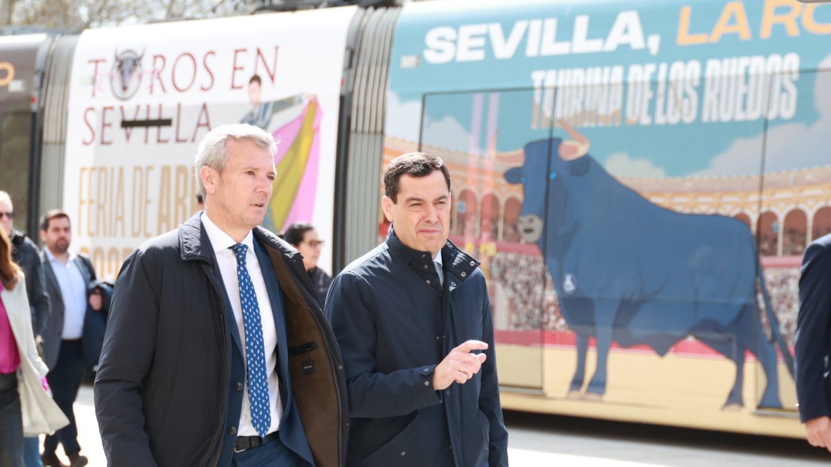 El presidente de la Junta de Andalucía, Juanma Moreno, y el de la Xunta de Galicia, Alfonso Rueda, caminan por el centro de Sevilla.
