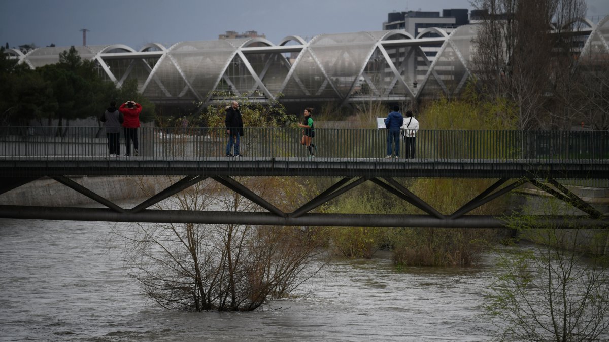 Varias personas, en el parque de Madrid Río, a 20 de marzo de 2025, en Madrid (España). El río Manzanares y las presas madrileñas de El Pardo se encuentran al borde de su capacidad por el paso de la borrasca Martinho y tras varias jornadas de intensas llu.