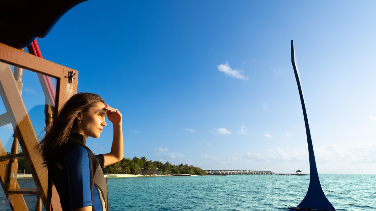 Buceadora en la proa de un dhoni, el barco tradicional de las islas Maldivas.