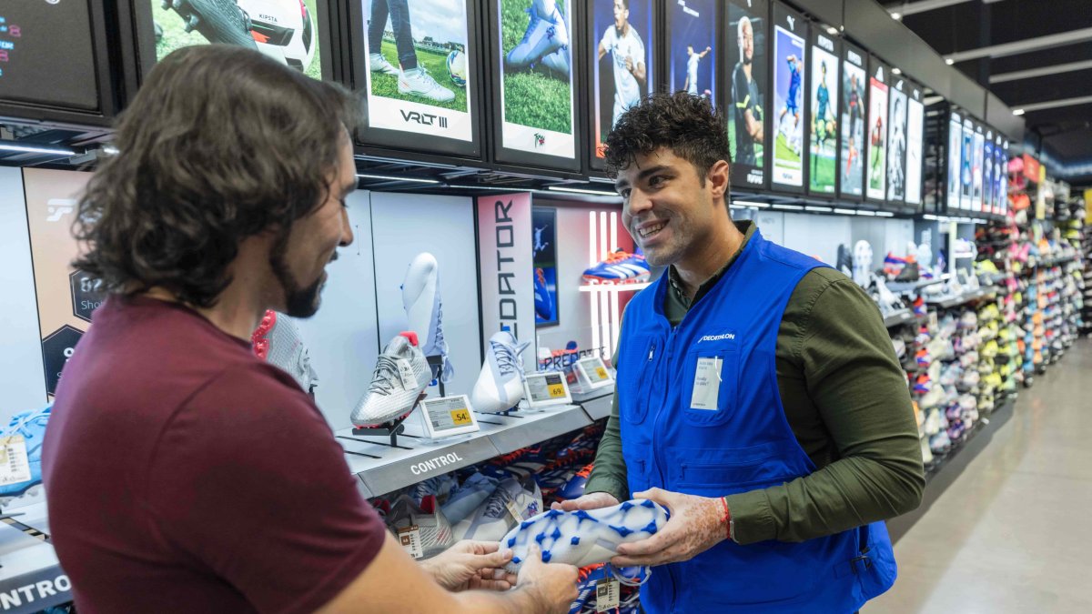 Trabajador de Decathlon ofreciendo unas