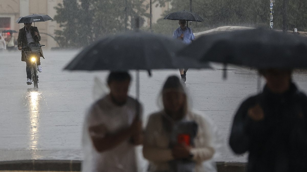 Varias personas con paraguas bajo la lluvia