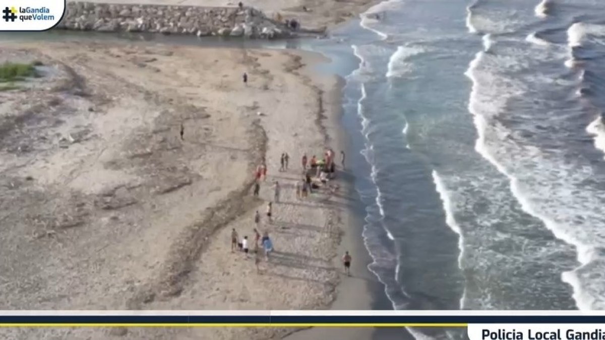 Agentes rescatan a dos bañistas en la playa de Gandia (Valencia)