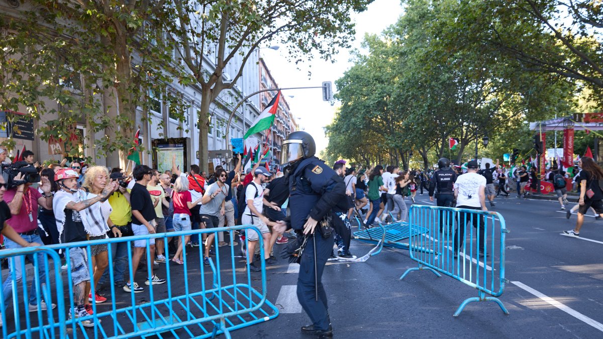 Un agente de Policía Nacional entre vallas tiradas tras cargas policiales a manifestantes que han protestado en favor de Palestina durante la última etapa de la Vuelta a España.