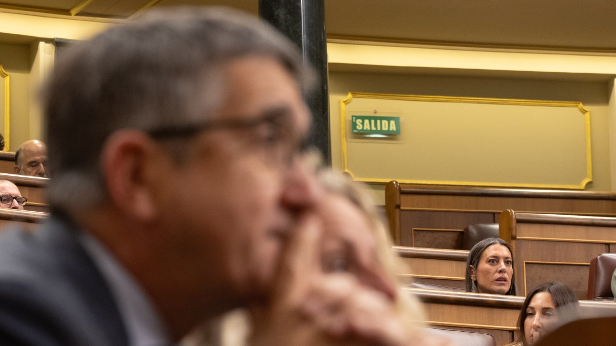 El portavoz del PSOE en el Congreso, Patxi López, en primer plano y la portavoz de Junts en el Congreso, Miriam Nogueras, al fondo, en su escaño.