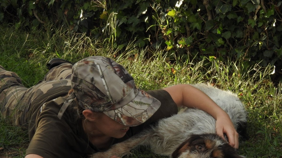 Cazadora dando mimos a su perro de caza y su buen amigo.