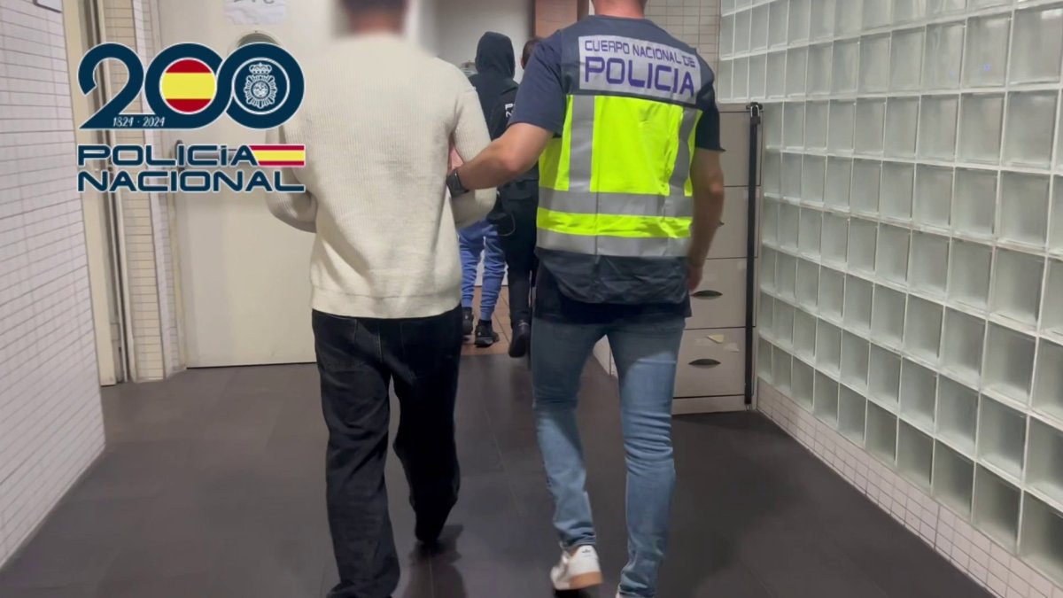Agentes de la Policía Nacional junto a uno de los detenidos