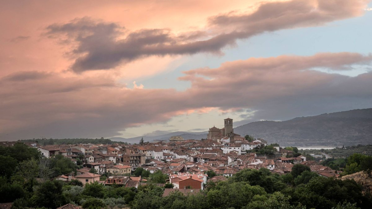 El perfil de Hervás al caer la tarde, con sus tejados rojizos y la silueta de la iglesia de Santa María, enmarcado por el cielo otoñal del Valle del Ambroz.