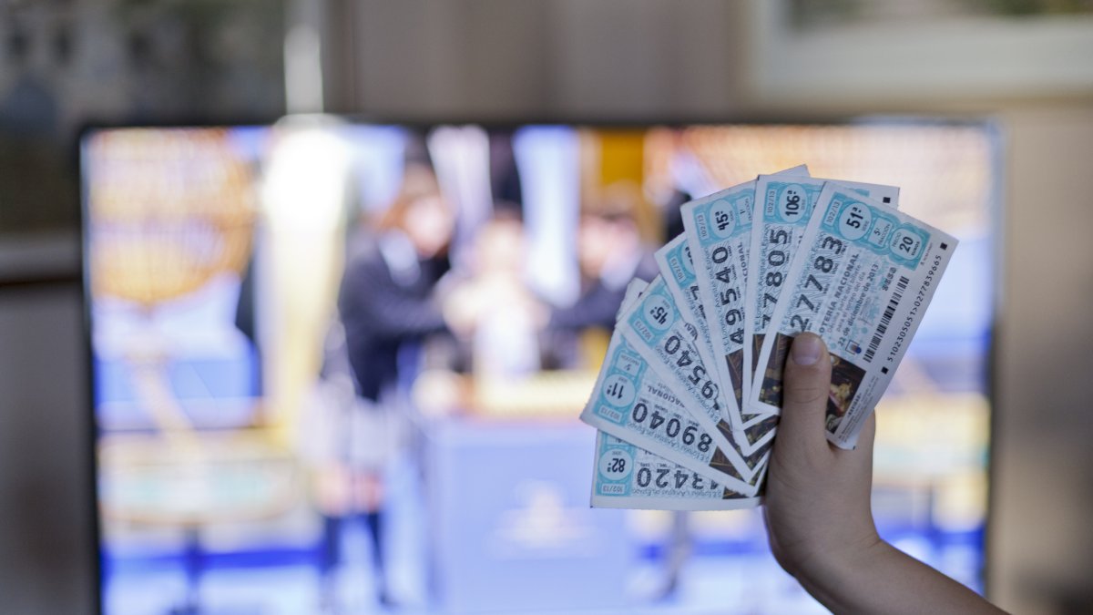 Boletos de lotería frente a la televisión