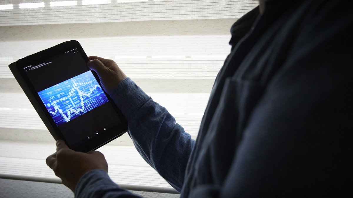 Un hombre sujeta una tablet con un gráfico, a 4 de enero de 2022, en Madrid, (España). 
Jesús Hellín / Europa Press
04 ENERO 2022