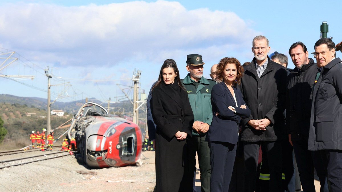 Foto del Rey Felipe VI y la Reina Letizia posando junto al tren Iryo descarrilado en Adamuz, flanqueados por María Jesús Montero, Óscar Puente y Juanma Mor