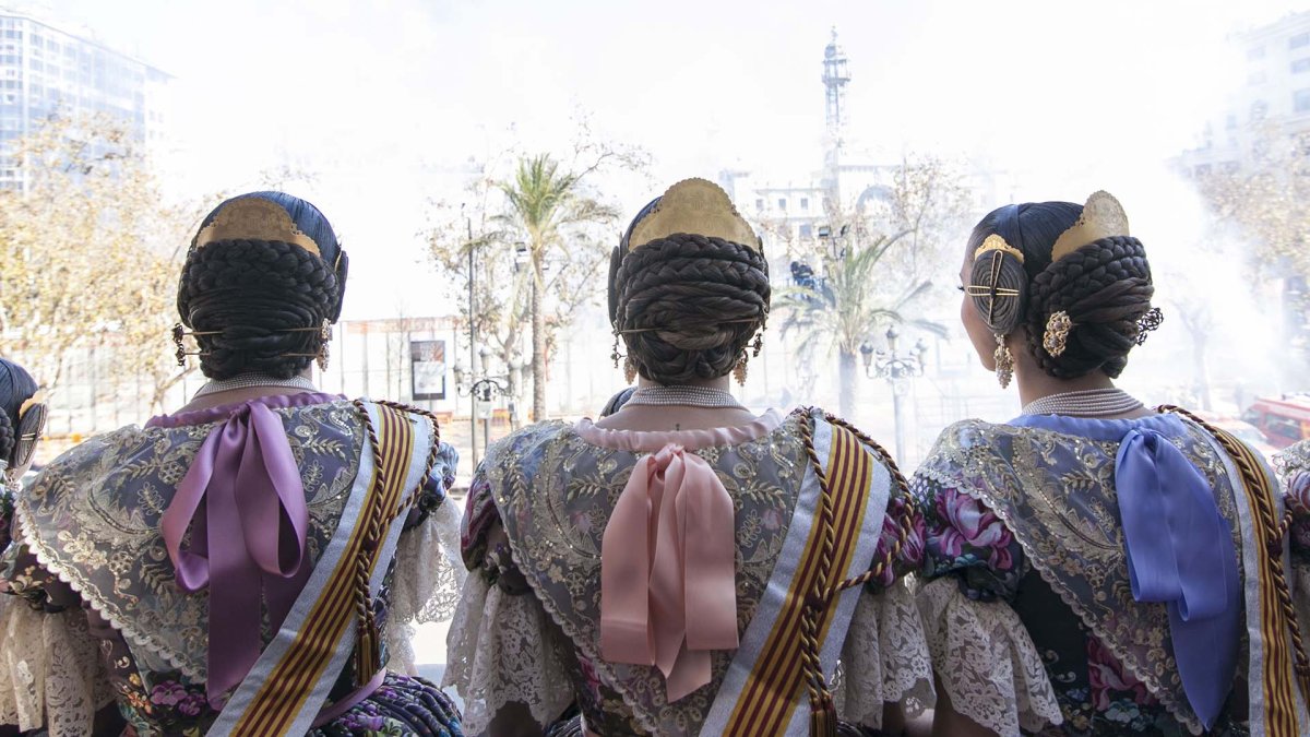 Falleras disfrutan de la mascletà desde el balcon del Ayuntamiento