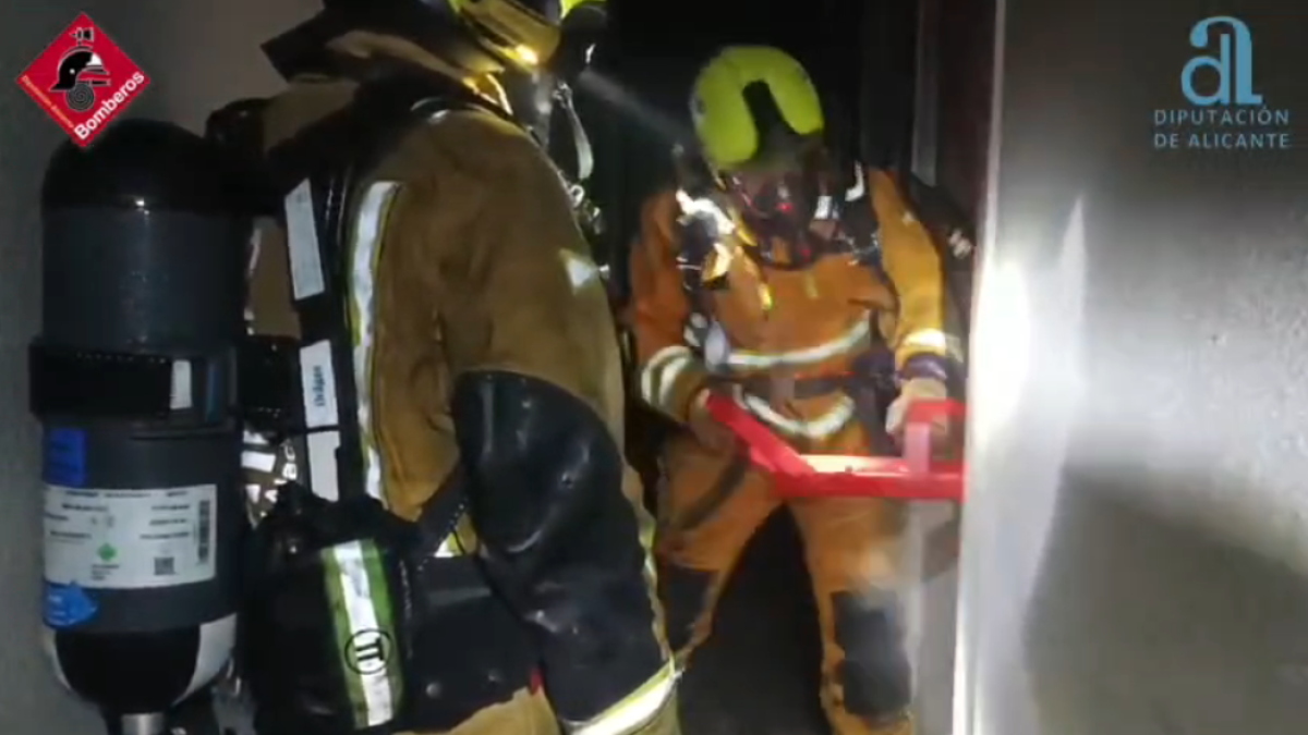 Momento en que los bomberos rompen la puerta de una de las estancias del hostal.