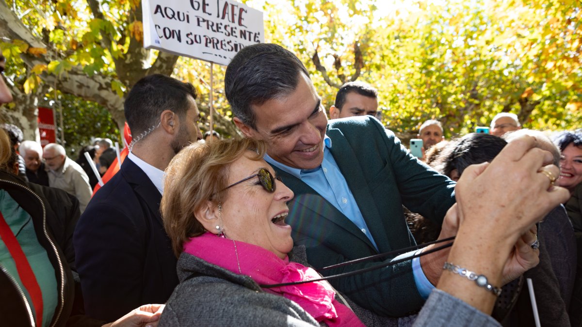 Pedro Sánchez se fotografía con una mujer en un mitin del PSOE en 2022.