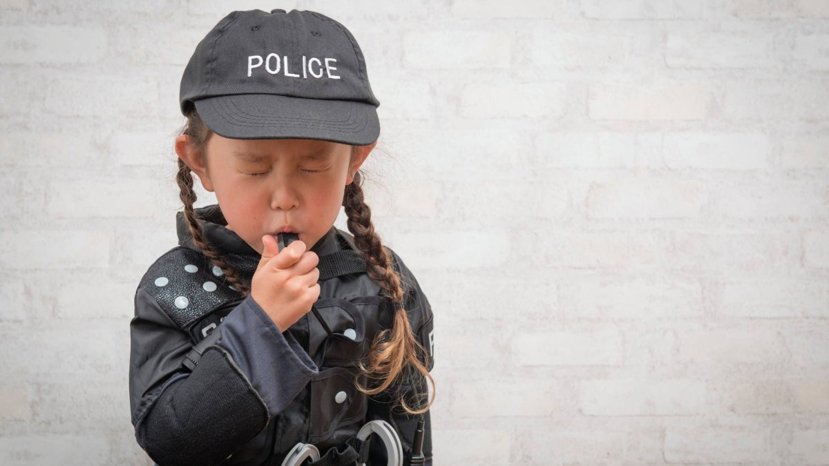 Una niña caracterizada como agente de policía sopla un silbato en plena celebración de Carnaval, un disfraz clásico que, en adultos, puede tener implicaciones legales si resulta demasiado realista.