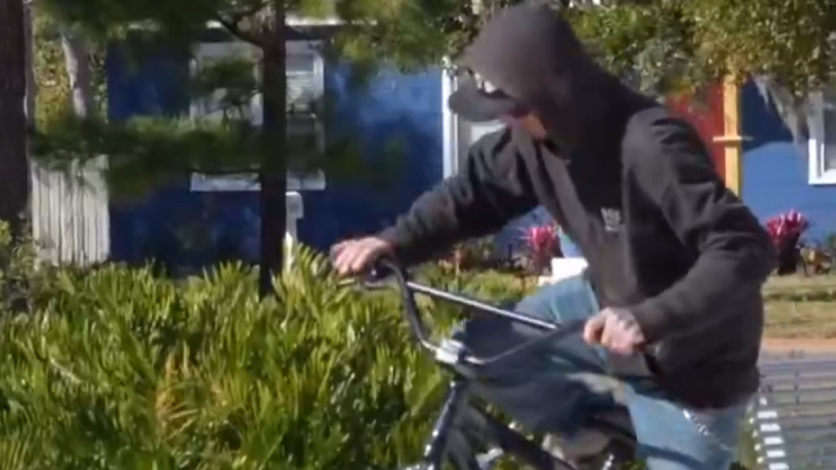 Uno de los ladrones intentando robar la bicicleta trucada.