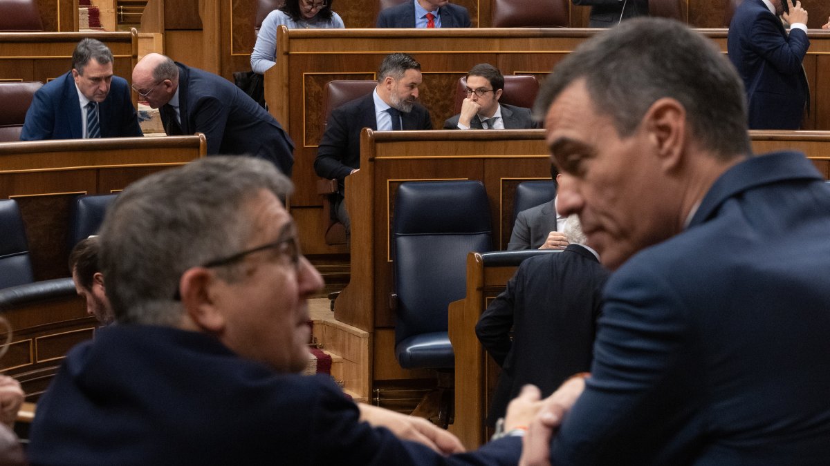 Patxi López y Pedro Sánchez charlan en el Congreso con el líder de Vox, Santiago Abascal, de fondo.