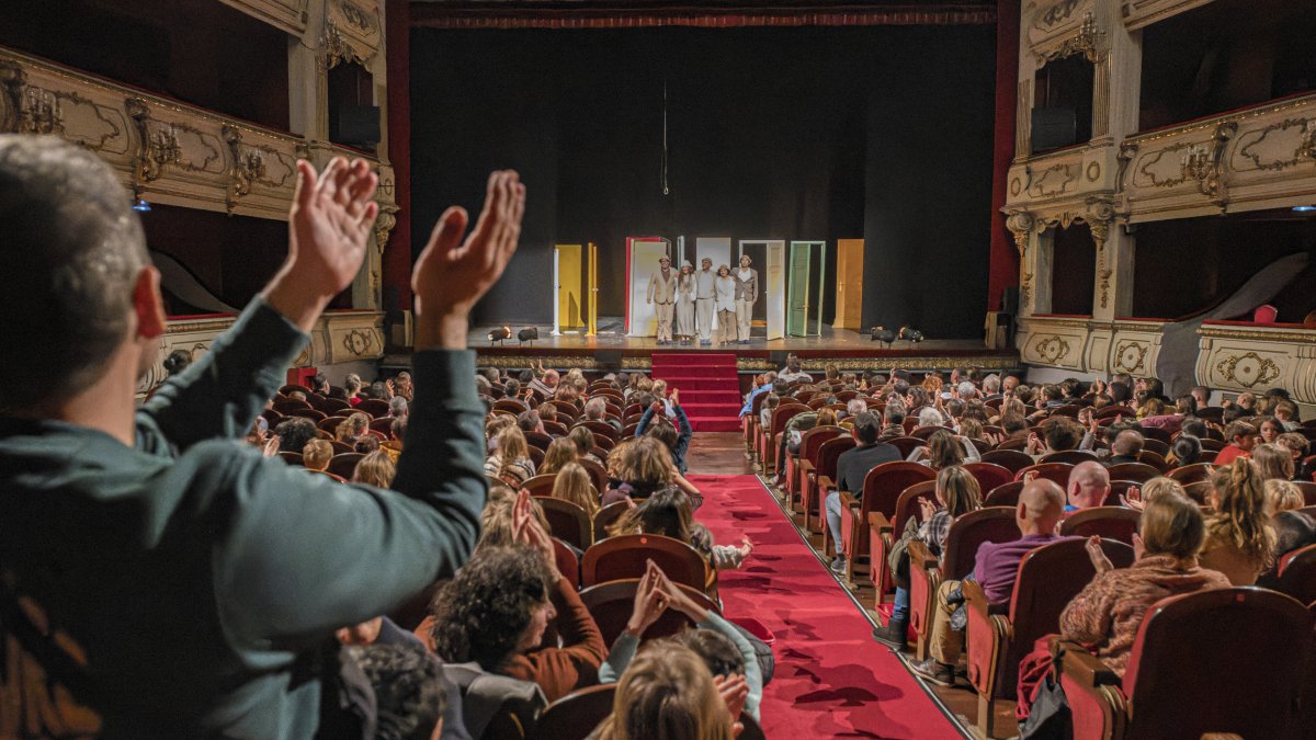 El patio de butacas de un teatro aplaude tras una función.