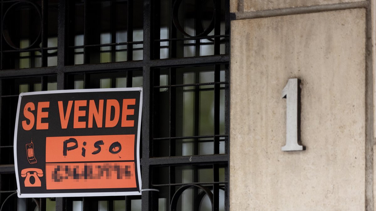 Vista de un cartel de 'Se vende' en un portal de un edificio.