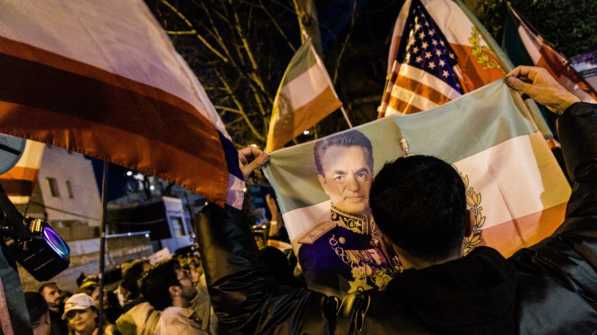 Decenas de personas durante una concentración de exiliados iraníes a favor de la intervención militar de EEUU e Israel, ante la embajada de Irán, a 28 de febrero de 2026, en Madrid.